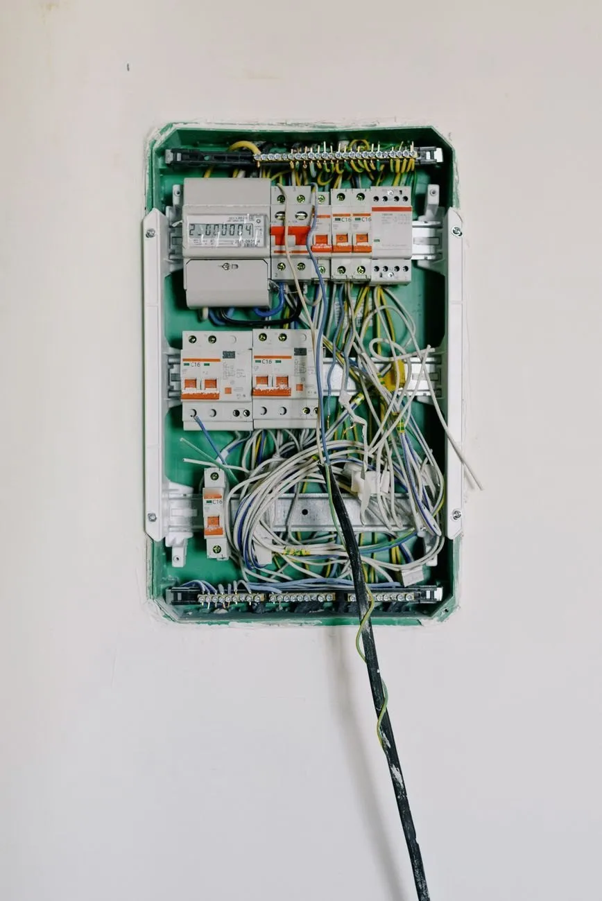 An open consumer unit with a row of circuit breakers and neatly dressed cables