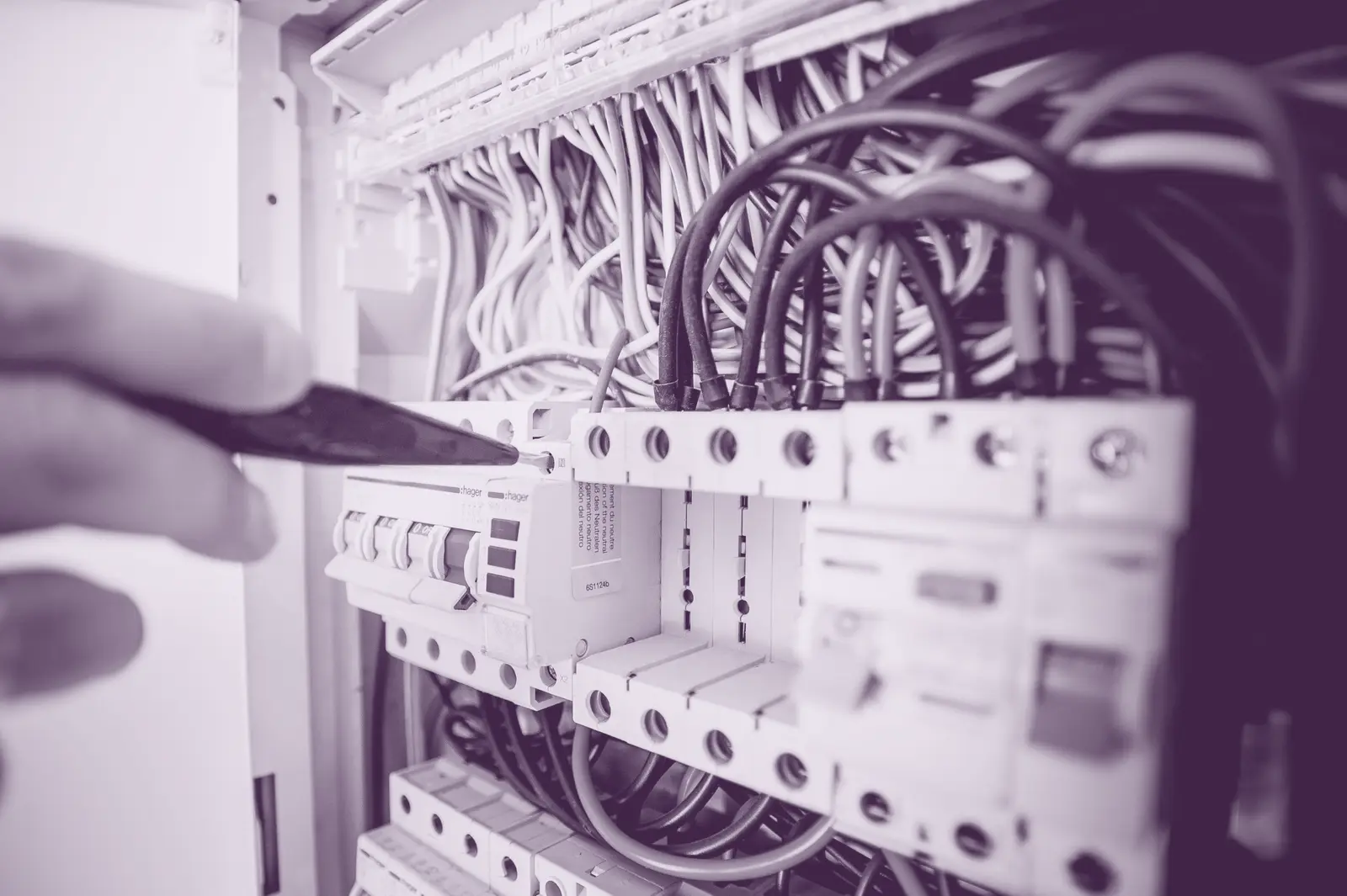 An electrician working on a live consumer unit